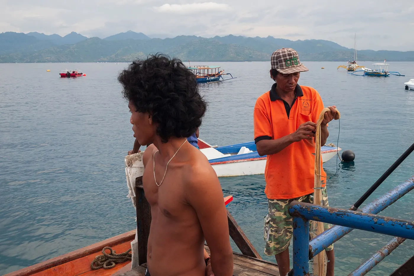 Nelayan menyiapkan alat tangkap di Gili Trawangan, dengan latar daratan Lombok. Foto: Vyacheslav Argenberg, Wikimedia Commons, CC BY 4.0
