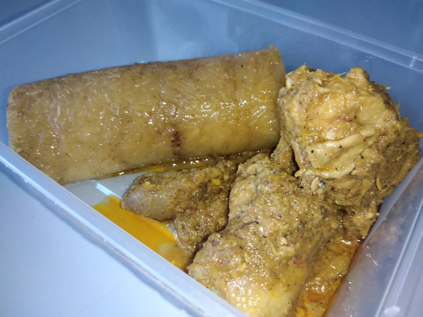 Beberapa potong lemang yang dimasak dalam ruas bambu disajikan bersama rendang ayam di atas piring