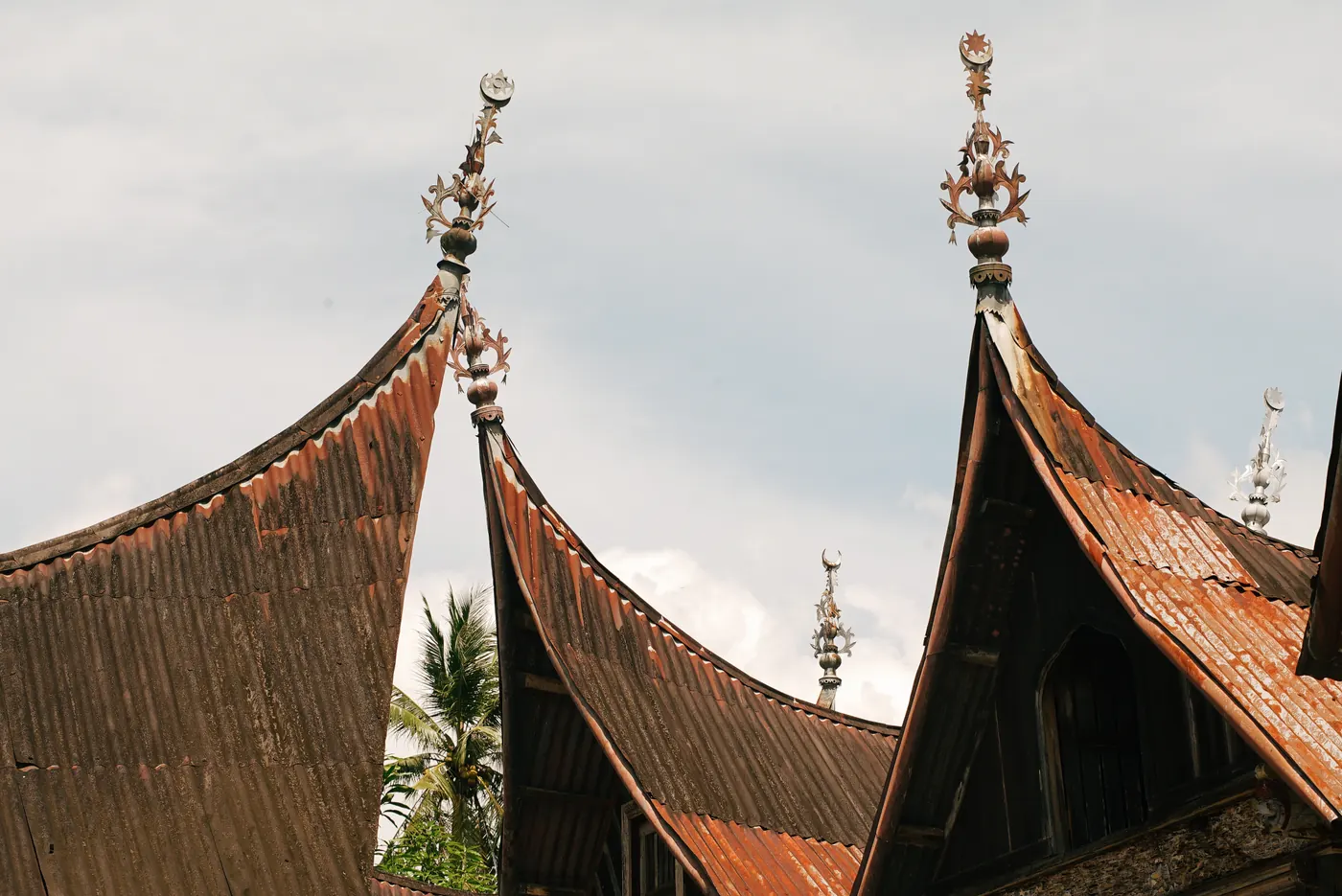 Ujung-ujung atap gonjong rumah gadang yang runcing melengkung ke atas dengan latar langit